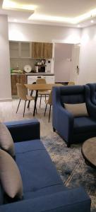 ein Wohnzimmer mit 2 blauen Sofas und einem Tisch in der Unterkunft فندق ايديا in Abha