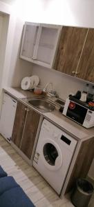 uma cozinha com uma máquina de lavar roupa e um lavatório em فندق ايديا em Abha