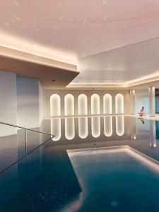 a swimming pool in a hotel with a room with a ceiling at Le Palace De Menthon in Menthon-Saint-Bernard