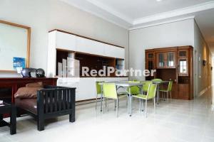 a dining room with a table and green chairs at Karawaci Victory Homestay Mitra RedDoorz in Tangerang