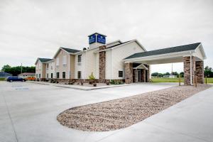 a large white building with a parking lot at Cobblestone Inn & Suites - Schuyler in Schuyler