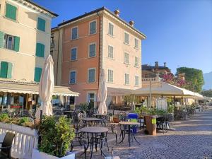 an outdoor patio with tables and chairs and umbrellas at Vistalago in Gargnano