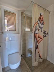 Una mujer está parada en un baño con aseo en Villa Ludilo mit 4 Apartments in Poljica - Marina bei Trogir Split, en Poljica
