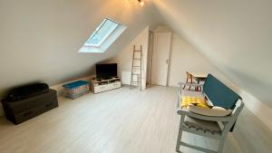 a attic room with a bed and a television at Petite maison de pêcheur au coeur du Crotoy in Le Crotoy
