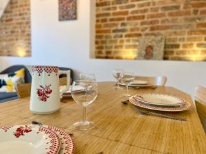 a wooden table with plates and wine glasses on it at Petite maison de pêcheur au coeur du Crotoy in Le Crotoy +2 photos