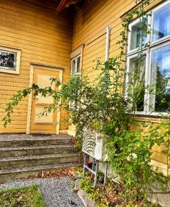 a house with a door and a tree in front of it at Saunaga korter Pärnu ranna vahetus läheduses in Pärnu