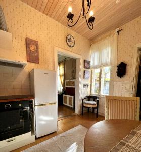 a kitchen with a white refrigerator and a table at Saunaga korter Pärnu ranna vahetus läheduses in Pärnu