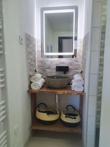 ein Badezimmer mit einem Waschbecken, einem Spiegel und Handtüchern in der Unterkunft -Garrigue- Face à la Cité médiévale studio terrasse classé 4☆ in Carcassonne