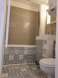 La salle de bains est pourvue de toilettes et de carrelage. dans l'établissement Appartement Saint Gervais les Bains piscine et vue imprenable Mont Blanc, à Saint-Gervais-les-Bains