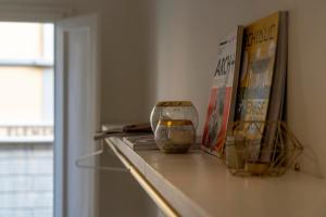 ein Regal mit Büchern und einer Vase darauf in der Unterkunft Memory Atelier - apartment in Florence in Florenz