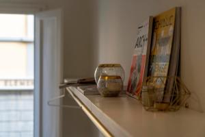 een plank met boeken en een vaas erop bij Memory Atelier - apartment in Florence in Florence