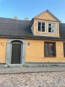 a wooden house with a large door and windows at KurBrauksim Windau Rooms in Ventspils