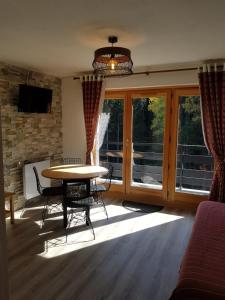 uma sala de estar com uma mesa e cadeiras e uma janela em Appartement Saint Gervais les Bains piscine et vue imprenable Mont Blanc em Saint-Gervais-les-Bains