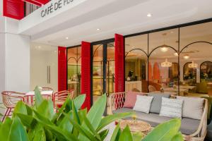 ein Geschäft mit roten Säulen, Tischen und Stühlen in der Unterkunft Hanoi Le Jardin Hotel & Spa in Hanoi