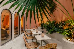 a restaurant with tables and chairs and a palm tree at Hanoi Le Jardin Hotel & Spa in Hanoi