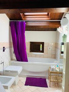 a bathroom with a tub and a purple shower curtain at Il Casale di Luisa in Modica