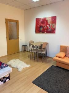 ein Wohnzimmer mit einem Tisch und einem Gemälde an der Wand in der Unterkunft apartman-Rača in Bratislava