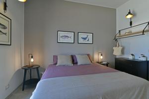 een slaapkamer met een groot bed en 2 tafels bij VILLA RARIKI in Scicli