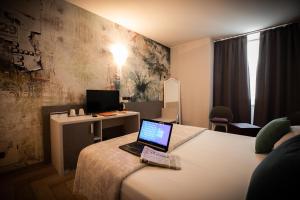 a hotel room with a laptop on a bed at Hotel Palazzo Lovera in Cuneo