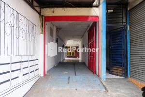 einen leeren Flur in einem Gebäude mit roter Tür in der Unterkunft Ninja Room Pasteur Mitra RedDoorz in Bandung
