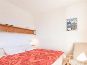 a bedroom with a bed and a chair at Appartement Saint-Chaffrey , 1 pièce, 4 personnes - FR-1-330E-43 in Serre Chevalier