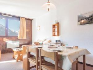 eine Küche mit Tisch und Stühlen und ein Zimmer mit Fenster in der Unterkunft Charmant studio 4 pers à Serre-Chevalier avec balcon, TV, lave-vaisselle - Animaux non admis - FR-1-330E-43 in Serre Chevalier