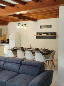 ein Wohnzimmer mit einem blauen Sofa, einem Tisch und Stühlen in der Unterkunft CHALET BOUTX 6 PERSONNES in Boutx