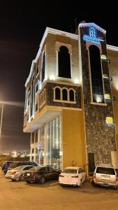 un edificio con coches estacionados en un estacionamiento en فندق ايديا, en Abha