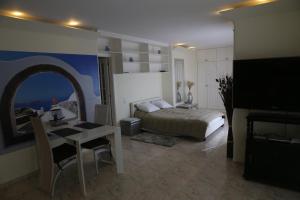 a bedroom with a bed and a table and a desk at Penthouse Ventur in Caniço