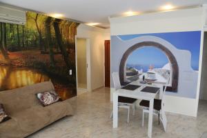 een woonkamer met een witte tafel en een schilderij bij Penthouse Ventur in Caniço