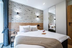 a bedroom with a large bed and a brick wall at Apartamenty Obora in Racibórz