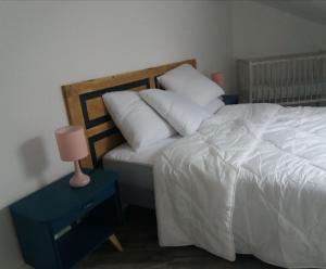 1 dormitorio con 1 cama y mesita de noche con lámpara en Appart Lumineux proche toutes commodités, en Souvigny