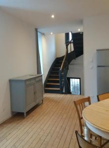 - un salon avec une table et un escalier dans l'établissement Appart Lumineux proche toutes commodités, à Souvigny