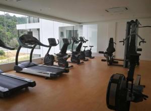 a gym with a row of treadmills and exercise bikes at Aeropod Sovo-Star Suite in Kota Kinabalu