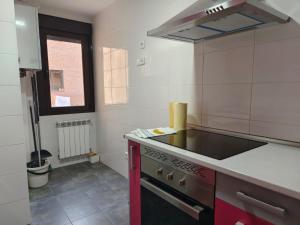 una cocina con fregadero y estufa horno superior en Apartamentos de Jaime, en Alcalá de Henares