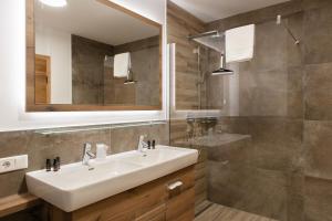 a bathroom with a sink and a mirror at AvenidA Style Appartements by Alpin Rentals in Kaprun