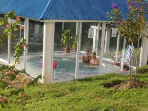 two people in a swimming pool in a house at Hosteria Rose Cottage in Otavalo