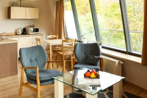 a kitchen and living room with a table and chairs at VisitZakopane - Cristal Apartment in Zakopane