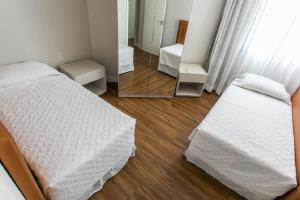 a bedroom with a bed and a mirror at Lindo apartamento na praia brava in Florianópolis +10 photos