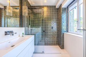 a bathroom with a shower with a sink and a glass shower door at Splendide Appartement de charme avec vue sur le Golf, proche plage et terrasse in Anglet