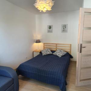 a bedroom with a blue bed and a blue couch at Mieszkanie z sercem - dwa pokoje, 300 m od morza in Ustka