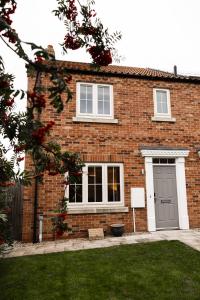 a brick house with a grey door and a yard at College Court in Bedale