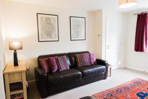 a living room with a black leather couch at College Court in Bedale