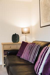 ein Sofa mit zwei Kissen auf einem Zimmer in der Unterkunft College Court in Bedale