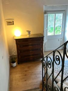 a bedroom with a dresser and a window at La Casina del Bassotto in Bagni di Lucca