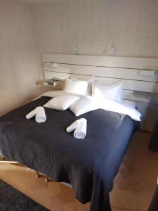 Una cama con almohadas blancas y toallas. en Asuntos-1 en Lahti