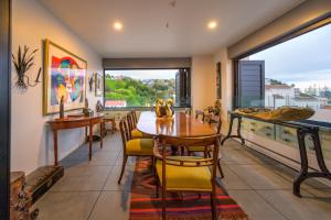 a dining room with a table and chairs and a window at The Address - Luxury 3 Bedroom Penthouse Apartment in Napier