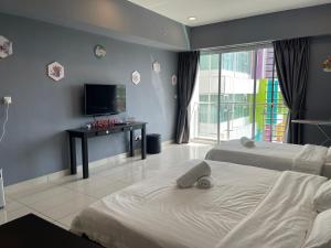 a bedroom with two beds and a flat screen tv at Aeropod Sovo-Star Suite in Kota Kinabalu