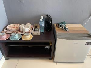 a table with plates and cups on top of a refrigerator at Aeropod Sovo-Star Suite in Kota Kinabalu