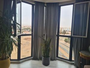 Cette chambre dispose de grandes fenêtres avec des plantes devant elles. dans l'établissement Dlalate, à Agadir